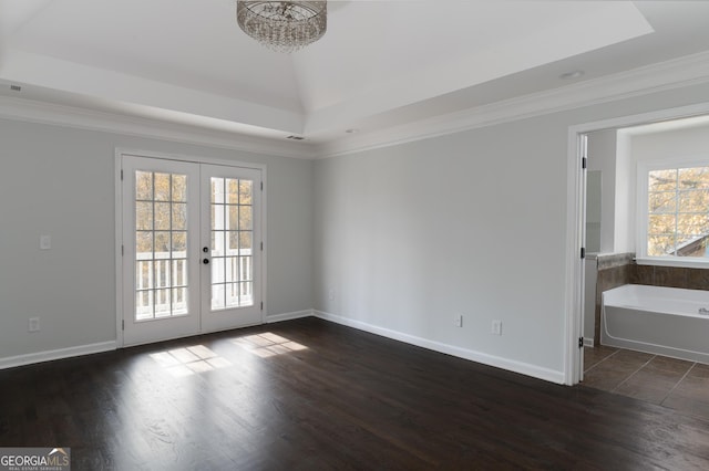 interior space with plenty of natural light, dark hardwood / wood-style flooring, ornamental molding, and french doors