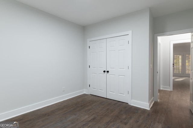 unfurnished bedroom featuring a closet and dark hardwood / wood-style floors