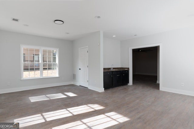 unfurnished living room featuring light hardwood / wood-style flooring and sink