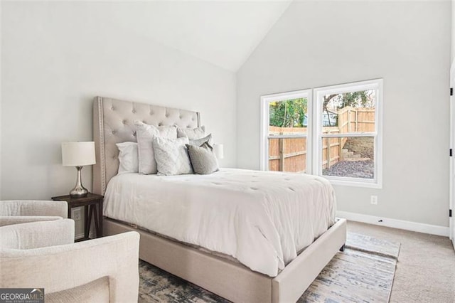 carpeted bedroom featuring high vaulted ceiling