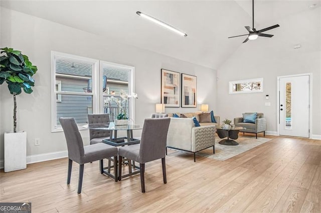 dining area featuring ceiling fan, high vaulted ceiling, and light hardwood / wood-style floors