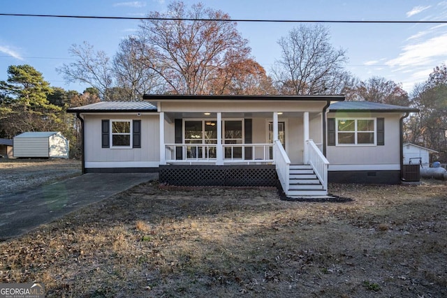 view of front of property featuring a porch, a storage unit, and central air condition unit