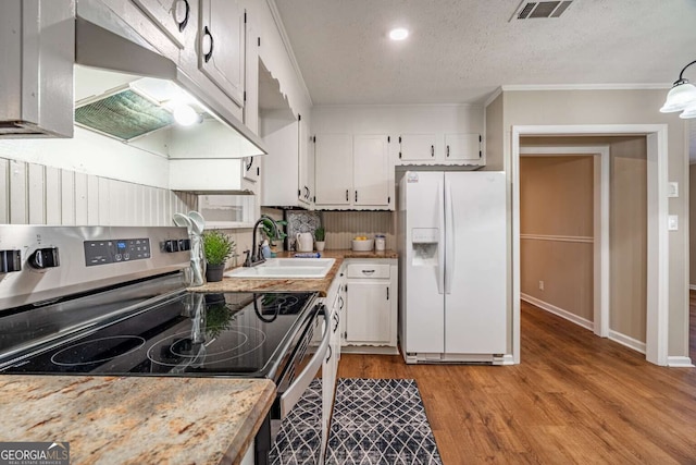 kitchen featuring sink, white cabinets, ornamental molding, white refrigerator with ice dispenser, and electric range