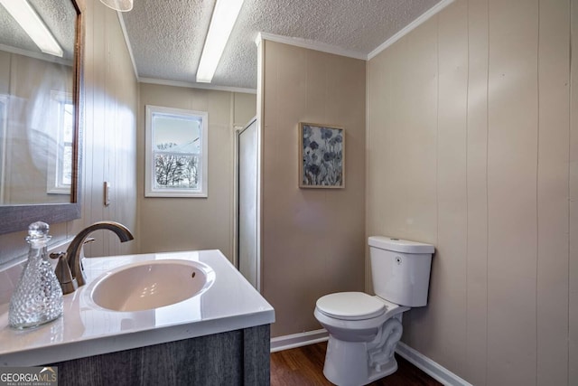 bathroom with hardwood / wood-style floors, vanity, ornamental molding, toilet, and a textured ceiling