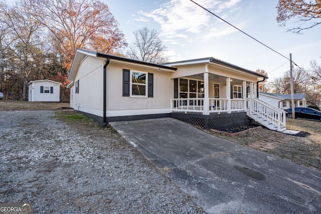 view of front of home featuring an outdoor structure and covered porch