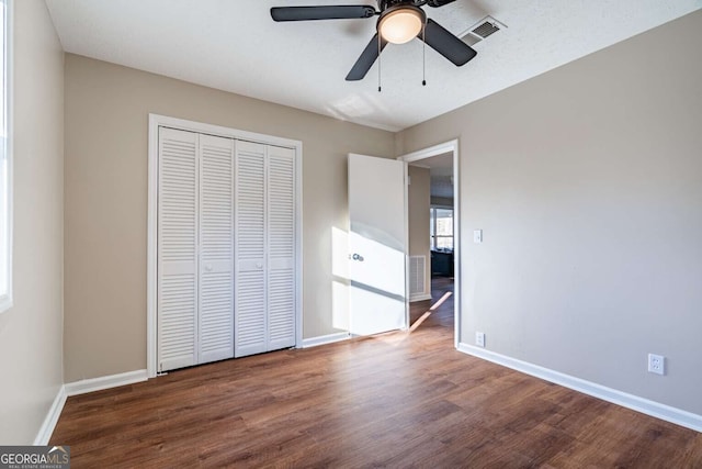 unfurnished bedroom featuring hardwood / wood-style floors, ceiling fan, and a closet