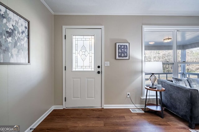 foyer with ornamental molding and dark hardwood / wood-style floors