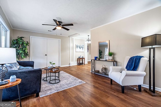 living room with crown molding, hardwood / wood-style floors, ceiling fan, and a textured ceiling