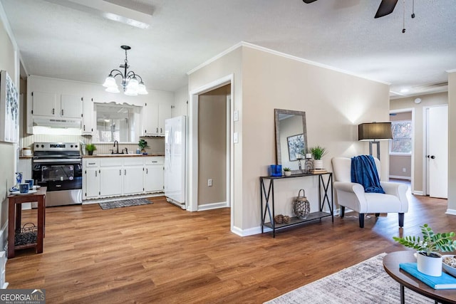 kitchen with white cabinetry, sink, stainless steel range with electric cooktop, white refrigerator, and hanging light fixtures