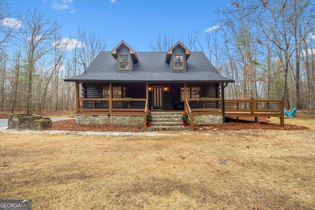 cabin with covered porch and a front lawn