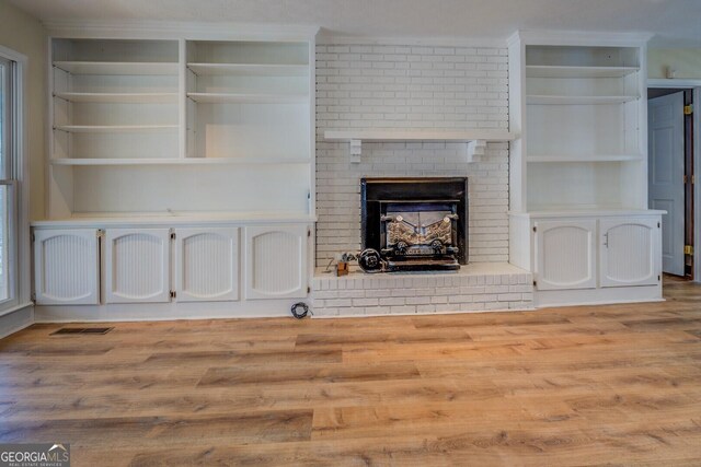 unfurnished living room featuring a fireplace and light hardwood / wood-style floors