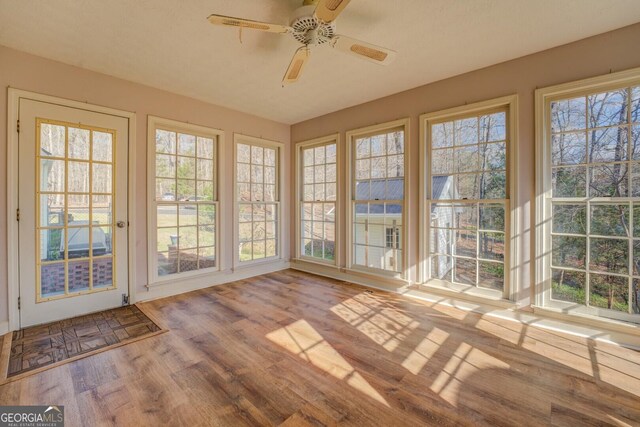 unfurnished sunroom featuring ceiling fan