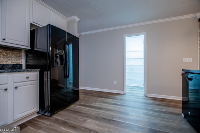 kitchen featuring tasteful backsplash, white cabinets, black appliances, and light hardwood / wood-style floors