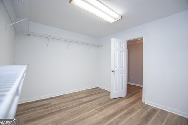 walk in closet with wood-type flooring