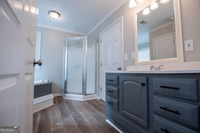 bathroom featuring hardwood / wood-style flooring, vanity, a shower with shower door, and ornamental molding