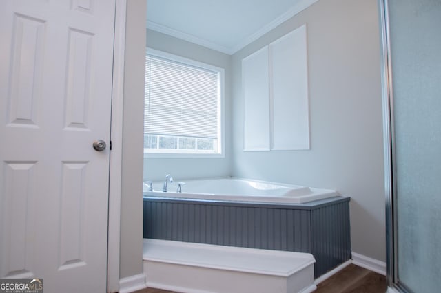 bathroom featuring a bathing tub, hardwood / wood-style floors, and ornamental molding