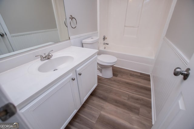 full bathroom with washtub / shower combination, hardwood / wood-style floors, vanity, and toilet