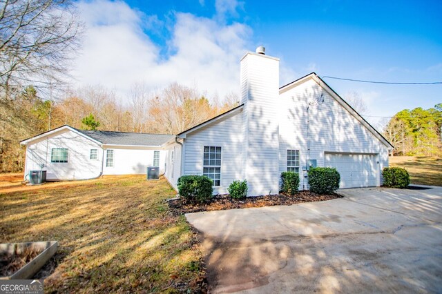 view of home's exterior with a yard, a garage, and cooling unit