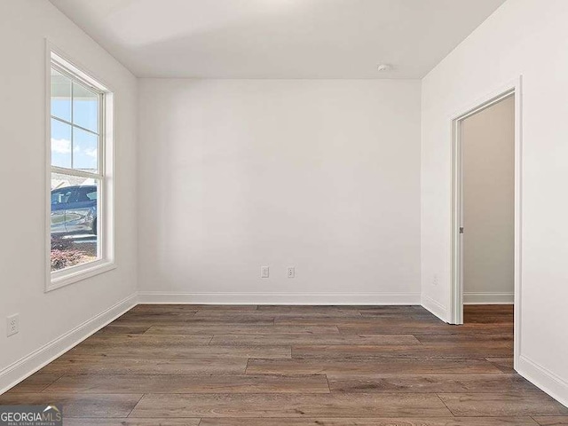 unfurnished room with dark hardwood / wood-style floors