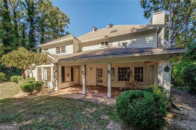 back of house with a lawn and a patio