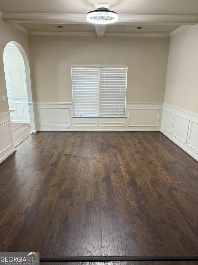 spare room with crown molding and dark wood-type flooring