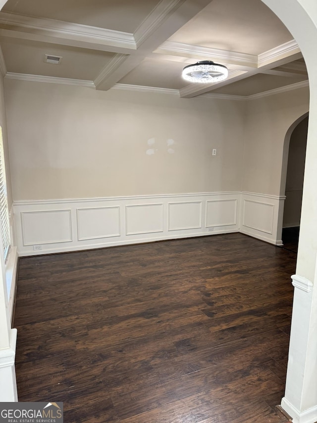 empty room with beam ceiling, dark hardwood / wood-style flooring, crown molding, and coffered ceiling