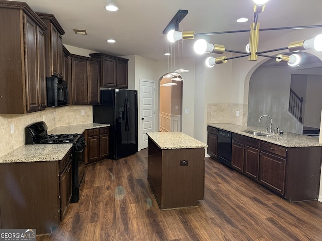 kitchen featuring kitchen peninsula, sink, black appliances, and dark wood-type flooring