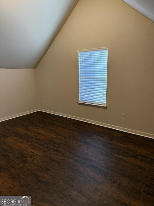 additional living space featuring dark hardwood / wood-style floors and lofted ceiling