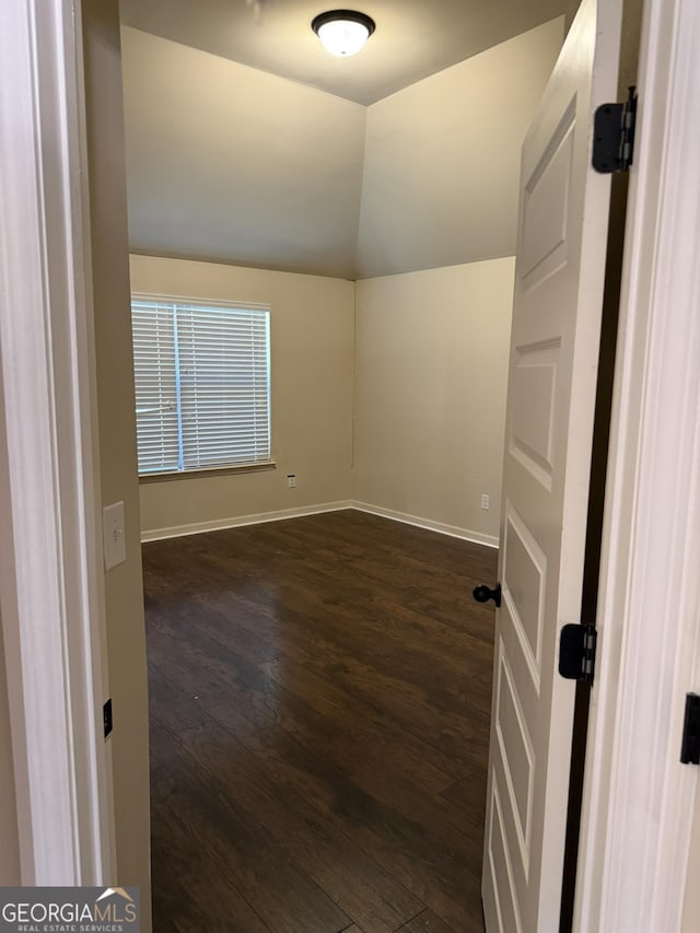 empty room featuring dark hardwood / wood-style flooring and lofted ceiling