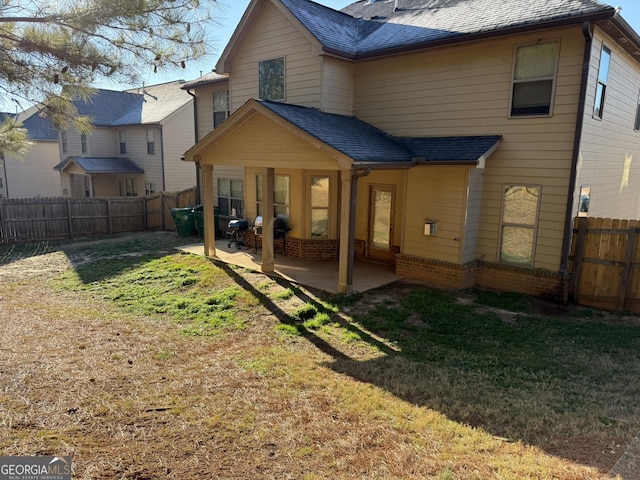 rear view of property with a patio area and a yard