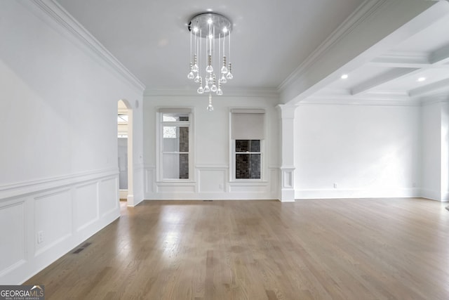 unfurnished living room featuring beamed ceiling, wood-type flooring, decorative columns, ornamental molding, and a notable chandelier