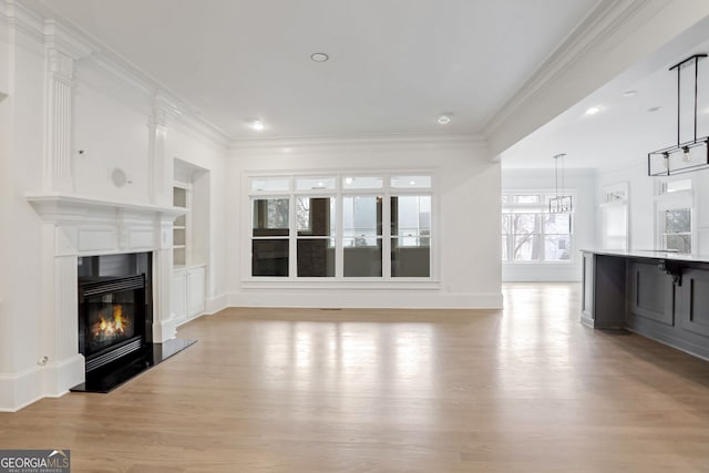 unfurnished living room featuring crown molding, light hardwood / wood-style flooring, and built in features