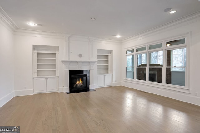 unfurnished living room with built in shelves, wood-type flooring, and ornamental molding