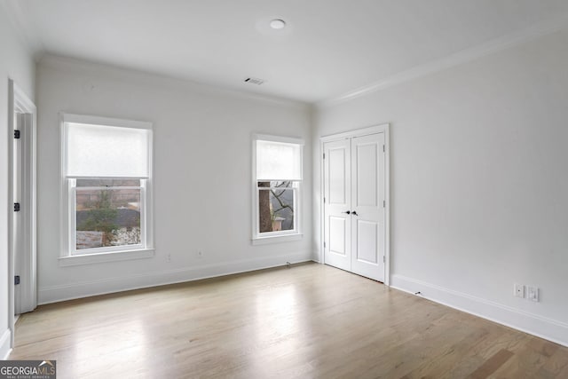 spare room with crown molding and light hardwood / wood-style flooring