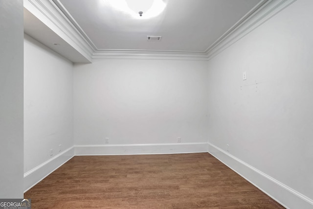 spare room featuring crown molding and wood-type flooring