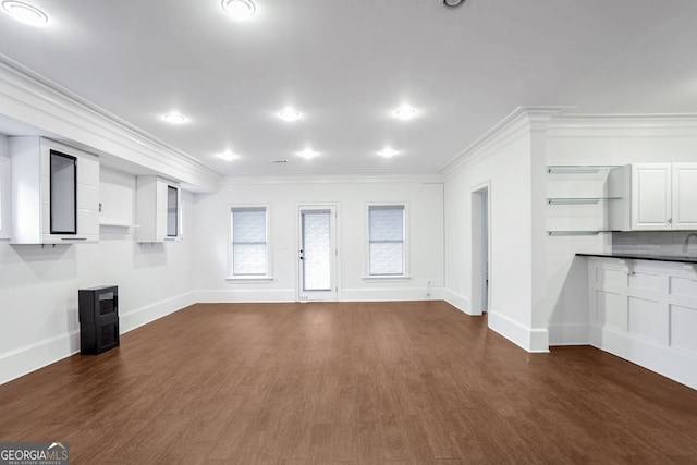 unfurnished living room with dark hardwood / wood-style flooring and ornamental molding