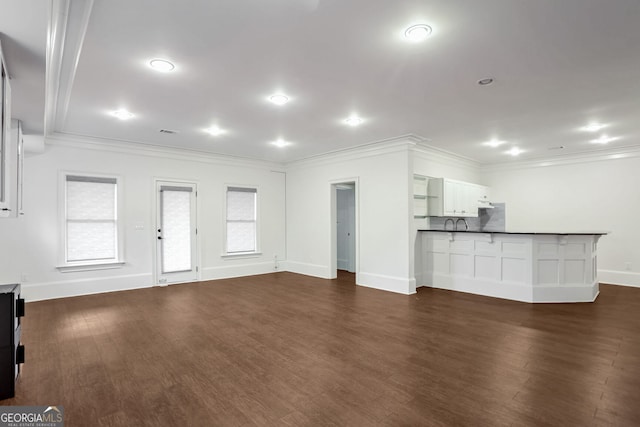 unfurnished living room with crown molding and dark hardwood / wood-style flooring