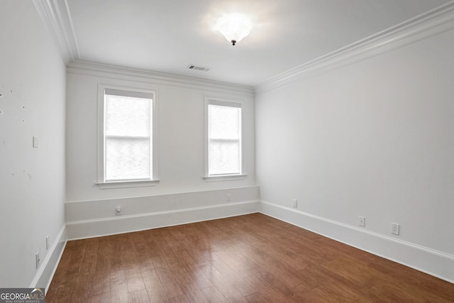 spare room featuring hardwood / wood-style flooring and ornamental molding