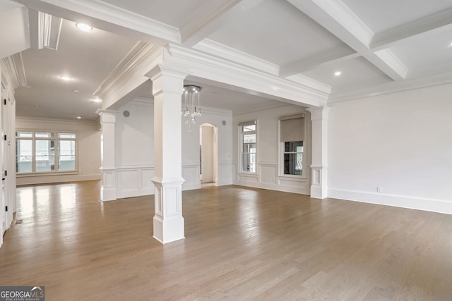 unfurnished living room featuring decorative columns, hardwood / wood-style flooring, and beamed ceiling