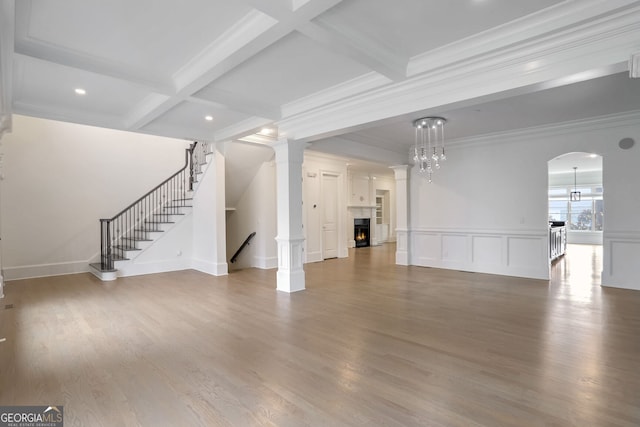 unfurnished living room with beamed ceiling, crown molding, hardwood / wood-style flooring, and coffered ceiling