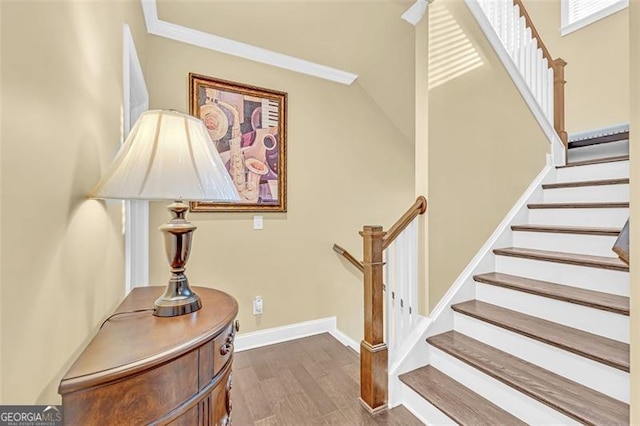 stairway with hardwood / wood-style flooring and crown molding