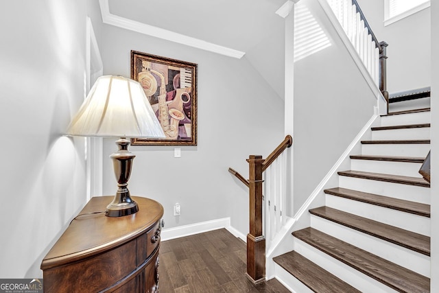 stairway with ornamental molding, lofted ceiling, baseboards, and wood finished floors