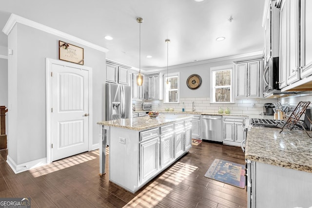 kitchen with decorative backsplash, dark wood-style floors, stainless steel appliances, crown molding, and a sink