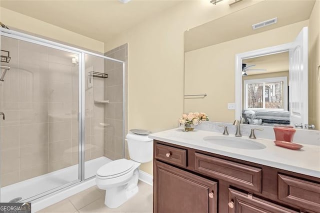 bathroom with ceiling fan, tile patterned flooring, an enclosed shower, toilet, and vanity