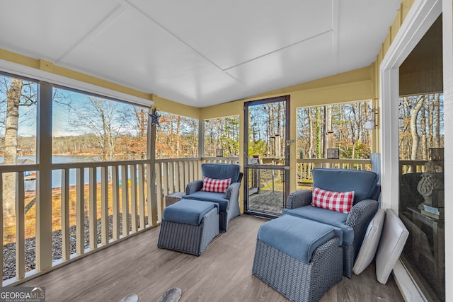 sunroom featuring a water view and lofted ceiling