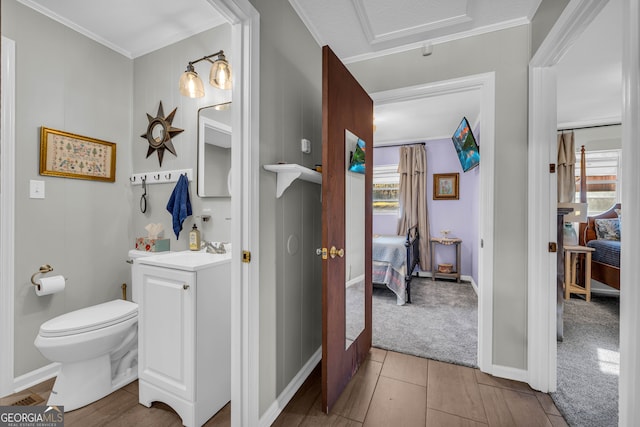 bathroom with tile patterned floors, vanity, toilet, and ornamental molding