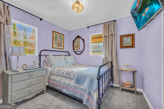 carpeted bedroom featuring multiple windows and ornamental molding