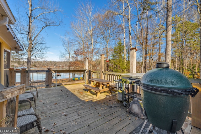 deck featuring a water view and a grill