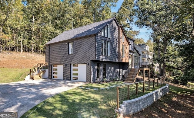 view of front of house featuring a front yard, a garage, and a wooden deck