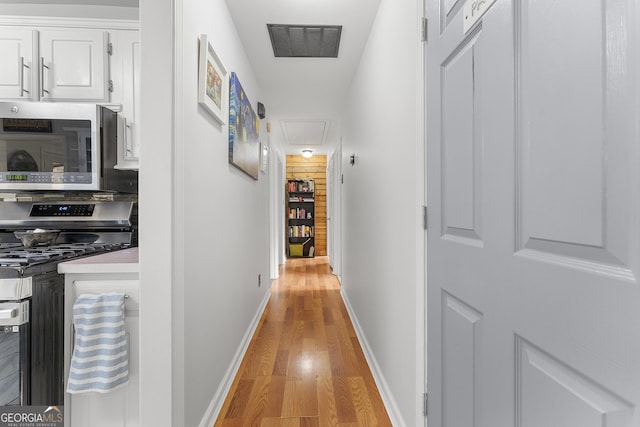 corridor with light hardwood / wood-style floors